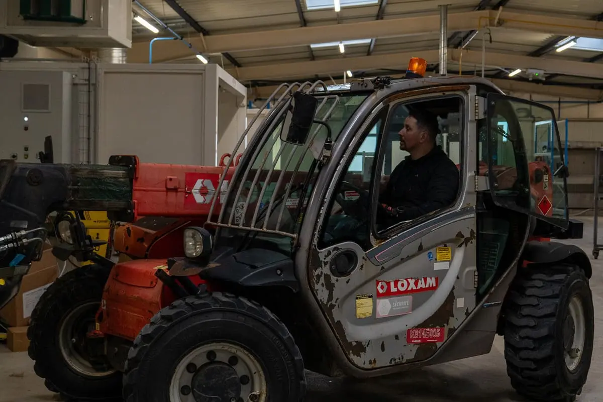 Technicien-sur-chariot-élévateur-lors-de-l’installation-d’un-tour-à-commande-numérique